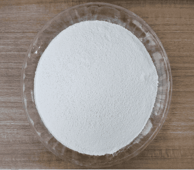 White heat resistant crosslinking agent powder shown as supplied in a glass dish CAPTION: Figure 1. The heat resistant crosslinking and anti-reversion agent as supplied.