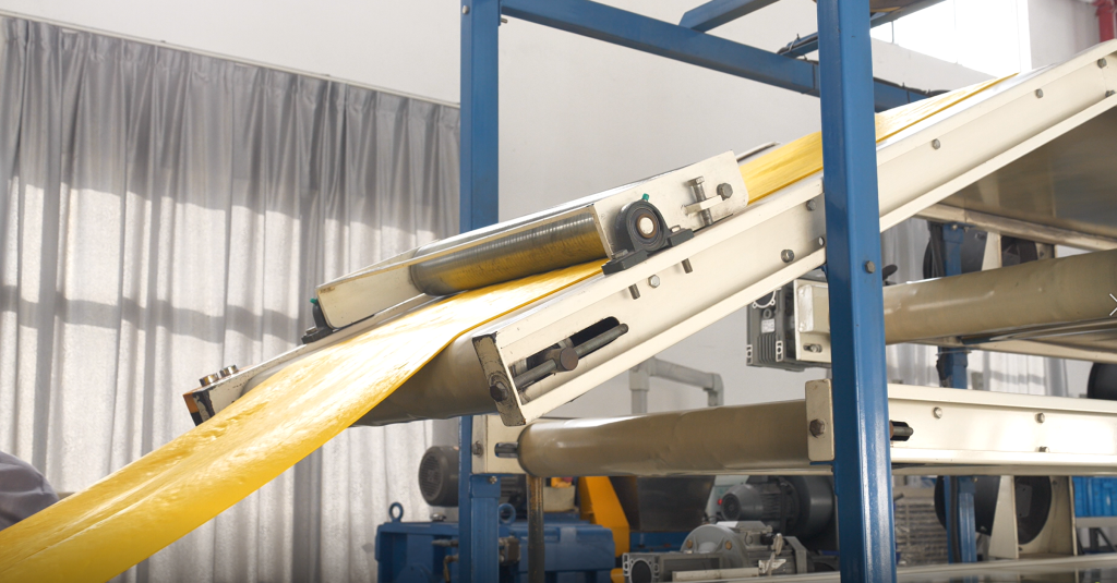 Perfectly uniform sheet of black FKM premix being calendered to a precise thickness, ready for easy handling and further processing.