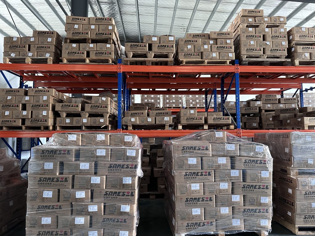 ：  neatly organized warehouse shelves and a sample wall displaying silicone samples in various colors and shapes 